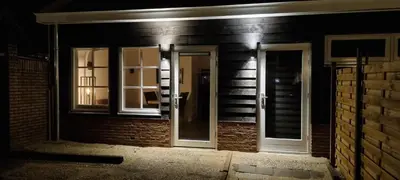 an open door to a brick building at night at De Rokerij in Monnickendam