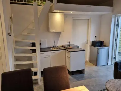 a kitchen with a sink and a staircase in a room at De Rokerij in Monnickendam