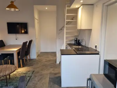 a kitchen and dining room with a sink and a table at De Rokerij in Monnickendam