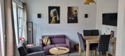 a living room with a purple couch and a table at De Rokerij in Monnickendam