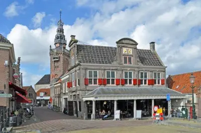 a large building with a clock tower on a street at De Rokerij in Monnickendam