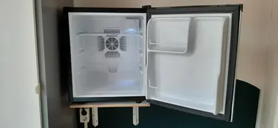 an empty refrigerator with its door open in a room at MICHELLE, not for parties, not a hotel, room with shared bathroom, no kitchen in Amsterdam