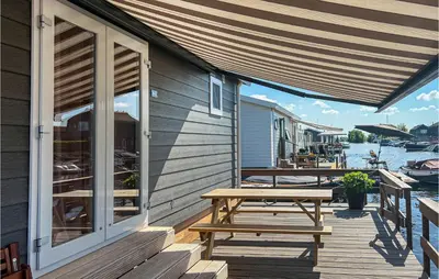 a wooden deck with a picnic table on a house at 2 Bedroom Awesome Home In Breukelen in Breukelen