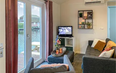 a living room with a couch and a sliding glass door at 2 Bedroom Awesome Home In Breukelen in Breukelen
