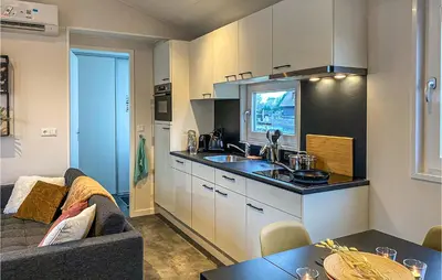 a kitchen with a sink and a couch in a room at 2 Bedroom Awesome Home In Breukelen in Breukelen