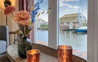 a table with a vase of flowers and a window at 2 Bedroom Awesome Home In Breukelen in Breukelen