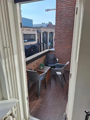 a balcony with chairs and a table on a building at Have a nice stay! - Apartment Duinvos 150m from the beach in Noordwijk aan Zee