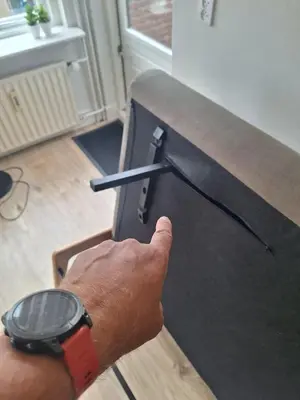 a person is pointing at a table with a watch at Have a nice stay! - Apartment Duinvos 150m from the beach in Noordwijk aan Zee