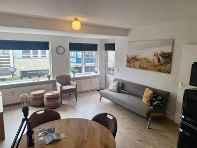 a living room with a couch and a table at Have a nice stay! - Apartment Duinvos 150m from the beach in Noordwijk aan Zee