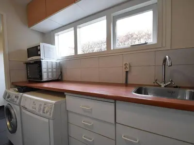 a small kitchen with a sink and a microwave at Vakantiehuis Duinwald, geschikt voor 8 personen in Bergen