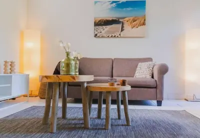 a living room with a couch and a table at Vakantiehuis Duinwald, geschikt voor 8 personen in Bergen