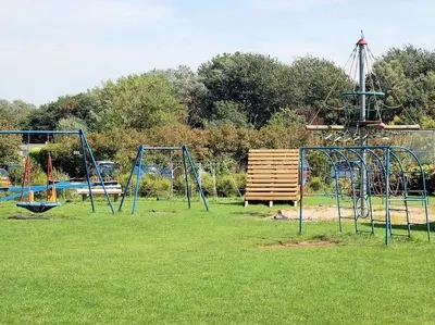 an empty park with two swings and a bench at Duinnest in Noordwijkerhout