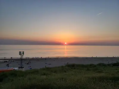 a group of people on a beach at sunset at Duinnest in Noordwijkerhout