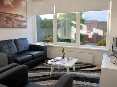 a living room with a couch and a table at Duinnest in Noordwijkerhout