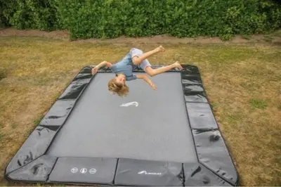 a girl laying on top of a trampoline at Glamping lodge with Eco-Wellness in Zeewolde