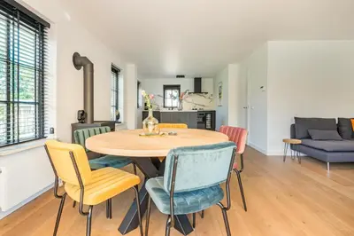 a kitchen and dining room with a table and chairs at Goudkust 4 'Schoorls Geluk' in Schoorl