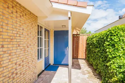 an entrance to a house with a blue door at Goudkust 4 'Schoorls Geluk' in Schoorl