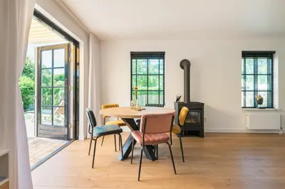 a dining room with a table and chairs and a fireplace at Goudkust 4 'Schoorls Geluk' in Schoorl