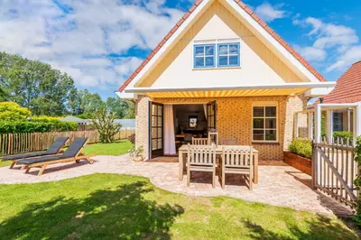 a house with two chairs and a patio at Goudkust 4 'Schoorls Geluk' in Schoorl