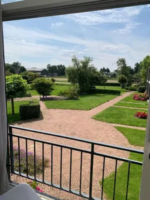 a view of a garden from a balcony at Have a nice stay! - Silt14 Sfeervol vakantie appartement in Noordwijk