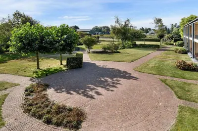 a brick walkway with a tree and a building at Have a nice stay! - Silt14 Sfeervol vakantie appartement in Noordwijk