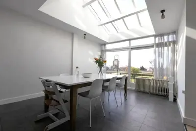 a dining room with a table and chairs and a window at Have a nice stay! - Silt14 Sfeervol vakantie appartement in Noordwijk