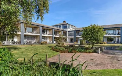an exterior view of a building with a yard at Have a nice stay! - Silt14 Sfeervol vakantie appartement in Noordwijk