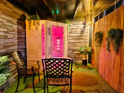 a porch with two chairs and a pink door at bnbheerhugowaard in Heerhugowaard