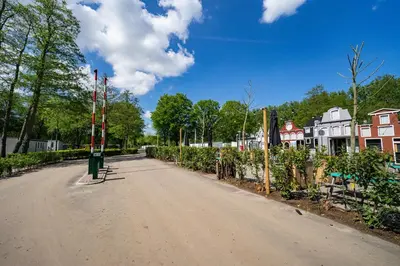 an empty street in a village with houses and trees at EuroParcs Het Amsterdamse Bos in Amstelveen