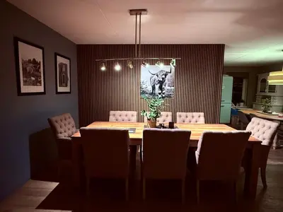 a dining room with a table and chairs at VILLA CALMA Rust Ruimte Luxe inclusief private jacuzzi in Zeewolde