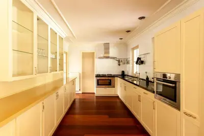 a large white kitchen with white cabinets and wood floors at 13P 5B Beautiful villa with heated Pool and Jacuzzi in Heerhugowaard
