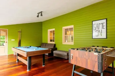 two ping pong tables in a room with green walls at 13P 5B Beautiful villa with heated Pool and Jacuzzi in Heerhugowaard