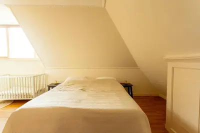 a bedroom with a white bed with two tables at 13P 5B Beautiful villa with heated Pool and Jacuzzi in Heerhugowaard