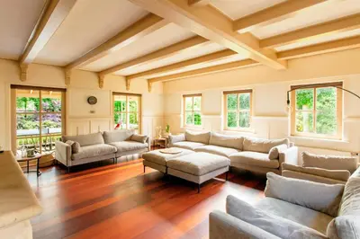 a living room with couches and tables and windows at 13P 5B Beautiful villa with heated Pool and Jacuzzi in Heerhugowaard