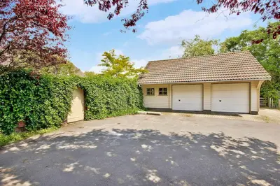 a house with two garage doors on a driveway at 13P 5B Beautiful villa with heated Pool and Jacuzzi in Heerhugowaard