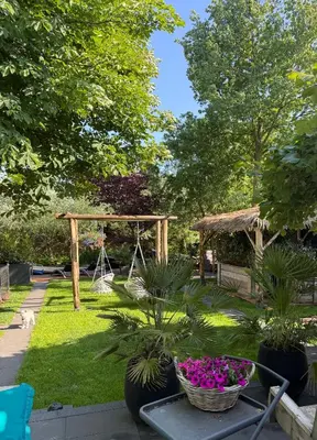a garden with a gazebo and some plants at Casa aan de Plas, B&B met sauna en hottub of jacuzzi in Nieuwkoop