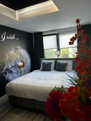 a bedroom with a bed with a flower mural on the wall at Casa aan de Plas, B&B met sauna en hottub of jacuzzi in Nieuwkoop