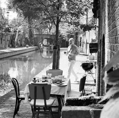 a woman walking down a street with a table and chairs at Vlinder's in Utrecht