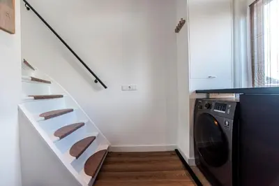 a laundry room with a staircase and a washing machine at Spacious Luxury Loft in Zandvoort