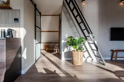 a hallway with a staircase and a potted plant at Spacious Luxury Loft in Zandvoort