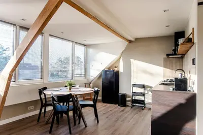 a kitchen and dining room with a table and chairs at Spacious Luxury Loft in Zandvoort