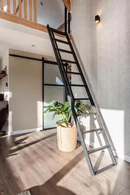 a metal staircase in a room with a potted plant at Spacious Luxury Loft in Zandvoort