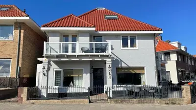a white house with a red roof at South Beach House in Zandvoort