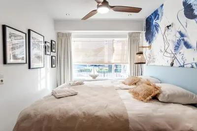 a bedroom with a large bed and a window at South Beach House in Zandvoort