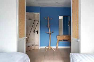 a bedroom with blue walls and a wooden door at South Beach House in Zandvoort