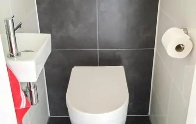 a bathroom with a white toilet and a sink at Bellevue in Bergen aan Zee