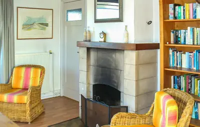 a living room with two chairs and a fireplace at Bellevue in Bergen aan Zee