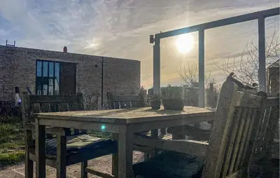 a wooden table and chairs on a patio at Bellevue in Bergen aan Zee