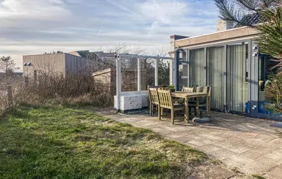 a patio with a table and chairs in a yard at Bellevue in Bergen aan Zee