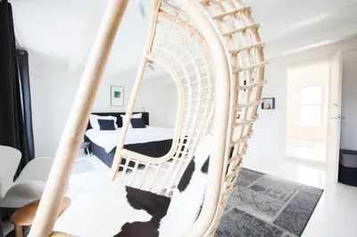 a swinging bed in a living room with a mirror at Mokum Suites in Amsterdam